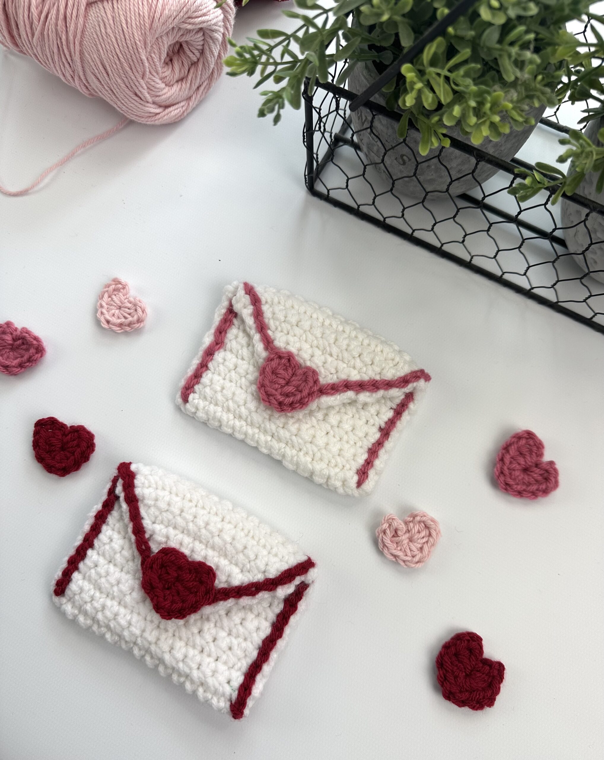2 white pink and red crocheted valentine envelopes with hearts