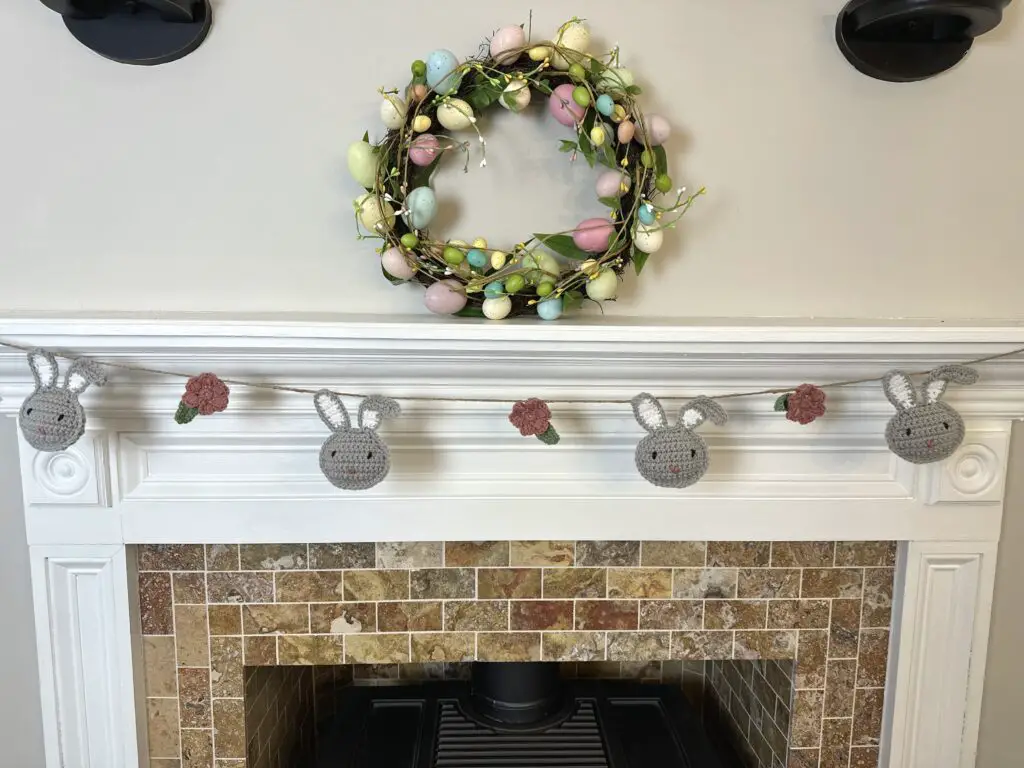 an easter bunny garland hanging on a fireplace mantle